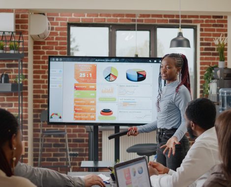 Close up of woman doing business presentation in boardroom, explaining charts analysis to workmates for comany development and growth. Employee presenting marketing strategy on screen.